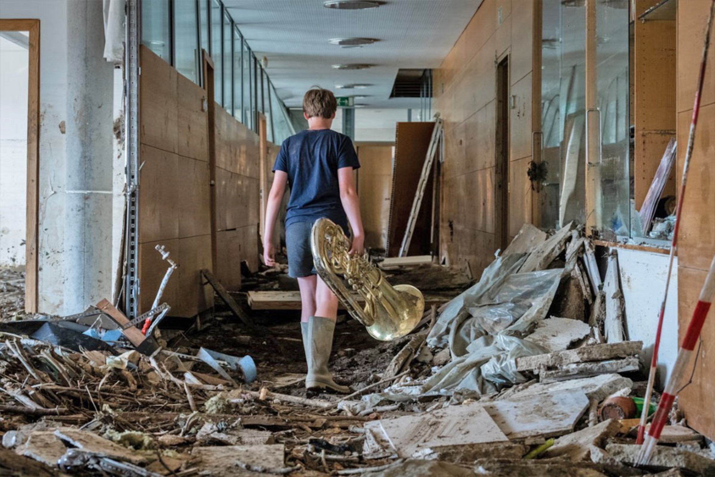 Ein Junge mit einem geretteten Musikinstrument: Das Hochwasser hat im Peter-Joerres-Gymnasium in Bad Neuenahr großen Schaden angerichtet.