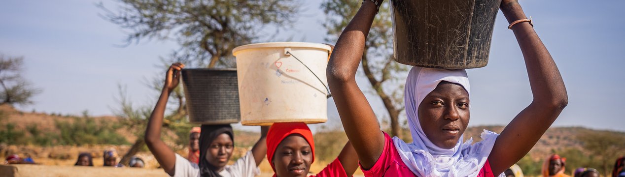 Mädchen an einem Brunnen in Mali