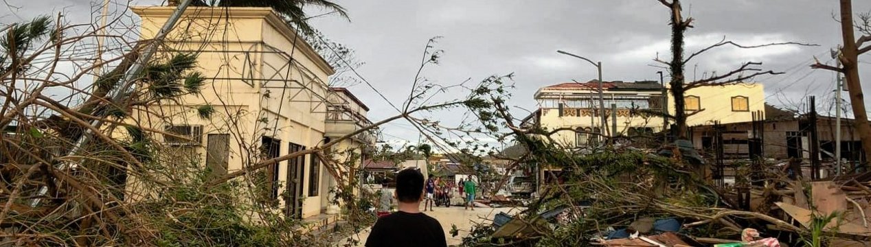 Ein Mann läuft durch eine von Taifun Rai zerstörte Siedlung auf den Philippinen