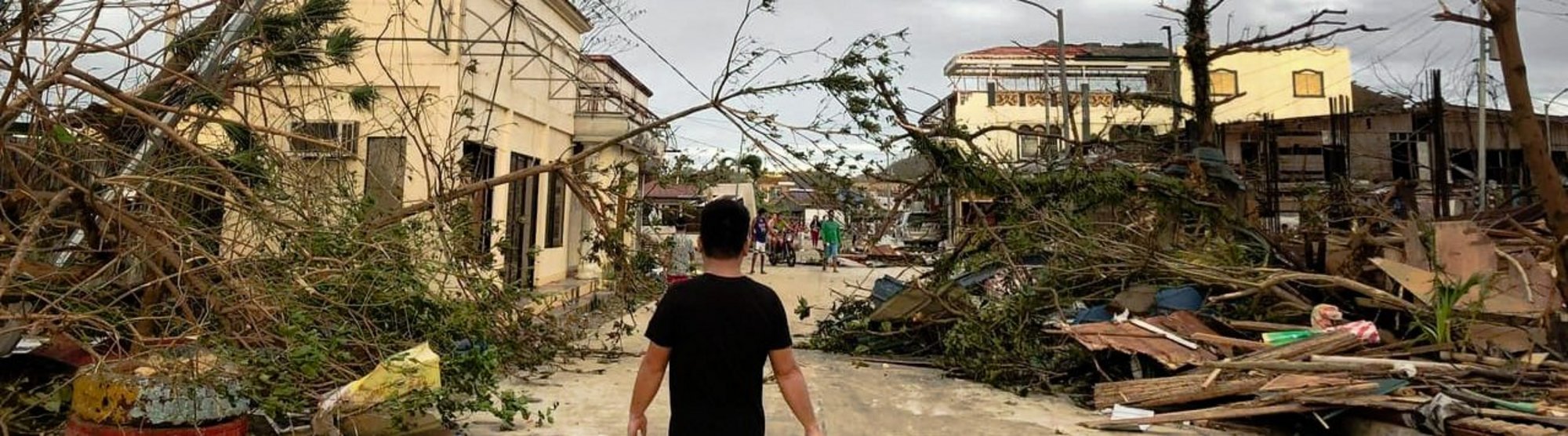 Ein Mann läuft durch eine von Taifun Rai zerstörte Siedlung auf den Philippinen